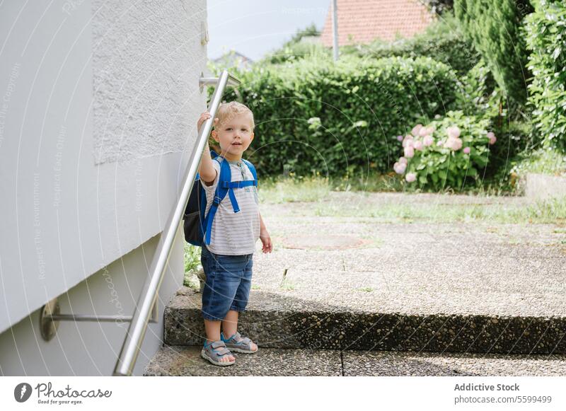 Happy child with backpack standing outside boy summer staircase casual smile cheerful kid happy cute adorable sun childhood positive daytime lifestyle