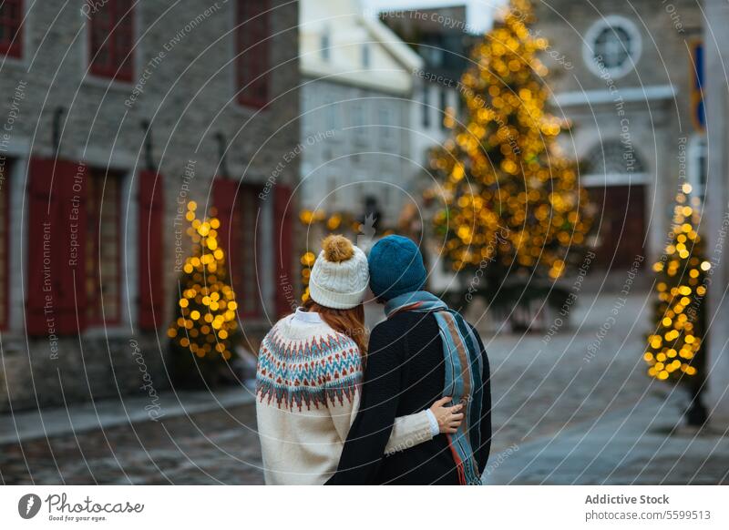 Couple embracing in a festive Christmas street in Quebec, Canada couple hug christmas quebec decoration sparkle architecture romance holiday winter charm