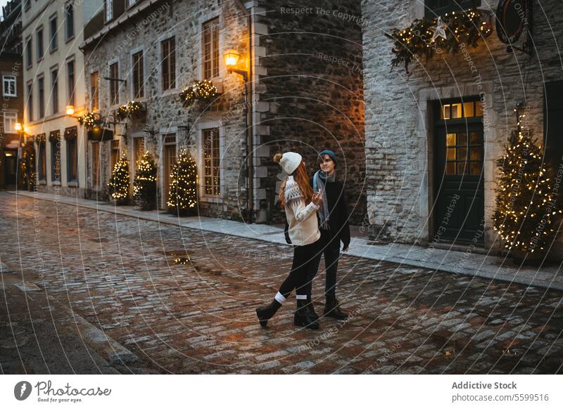 Couple enjoying a festive Christmas street scene in Quebec, Canada couple christmas holiday decoration light romantic walk illuminated season celebration