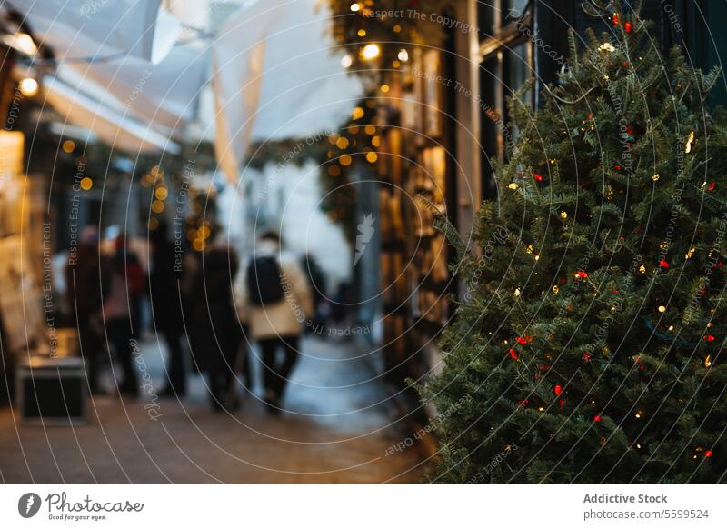 Christmas market atmosphere with festive decorations christmas shoppers lights decorated tree holiday season spirit stroll celebration outdoor winter bokeh
