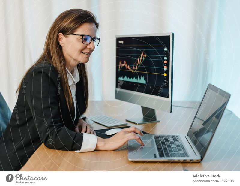 Smiling female trader working on laptop woman broker binary option using browsing chart graph financial monitor computer smile analyst investment online