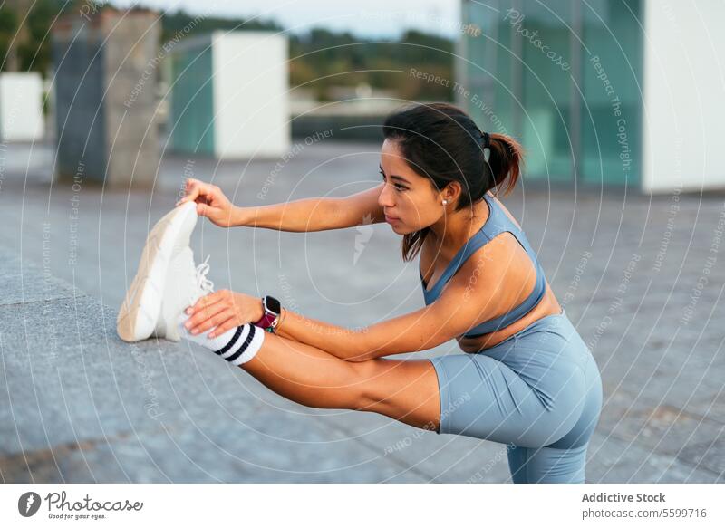 Outdoor fitness stretch by a Latin American woman. latin american stretching outdoor sportswear athlete healthy active lifestyle exercise wellness athletic