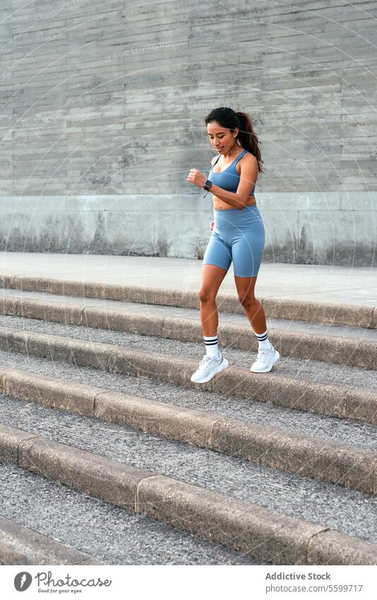 Active Latin American Woman Jogging Up Stairs woman latin american jogging stairs workout sportswear active fitness exercise outdoor focused health wellbeing