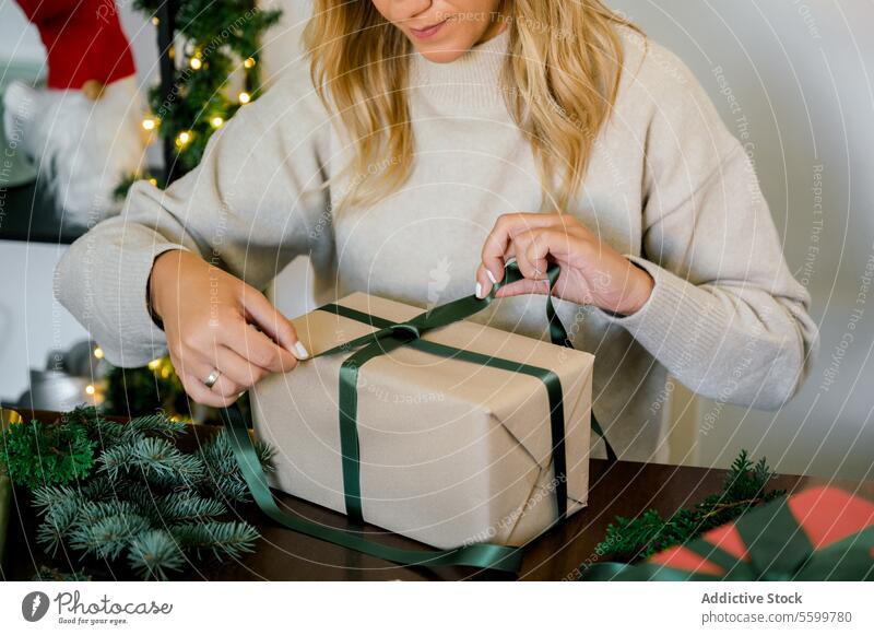 woman wrapping christmas gift at home horizontal ribbon professional person objects event paper decorating indoor female surprise packing seasonal