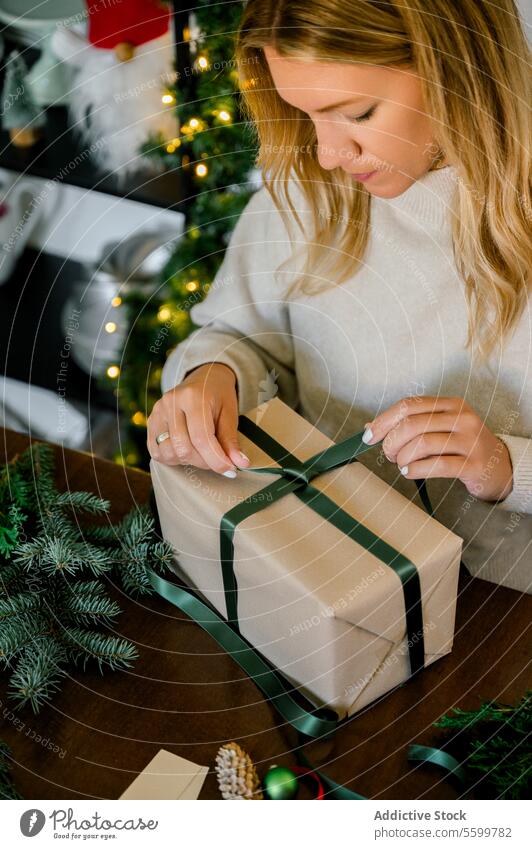 woman wrapping christmas gift at home ribbon professional person objects event paper decorating indoor female surprise packing seasonal christmas present
