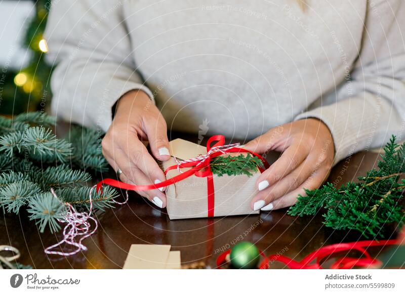 An unrecognizable woman holding Christmas gift in hand horizontal ribbon person paper decorating indoor happy female bow home surprise seasonal