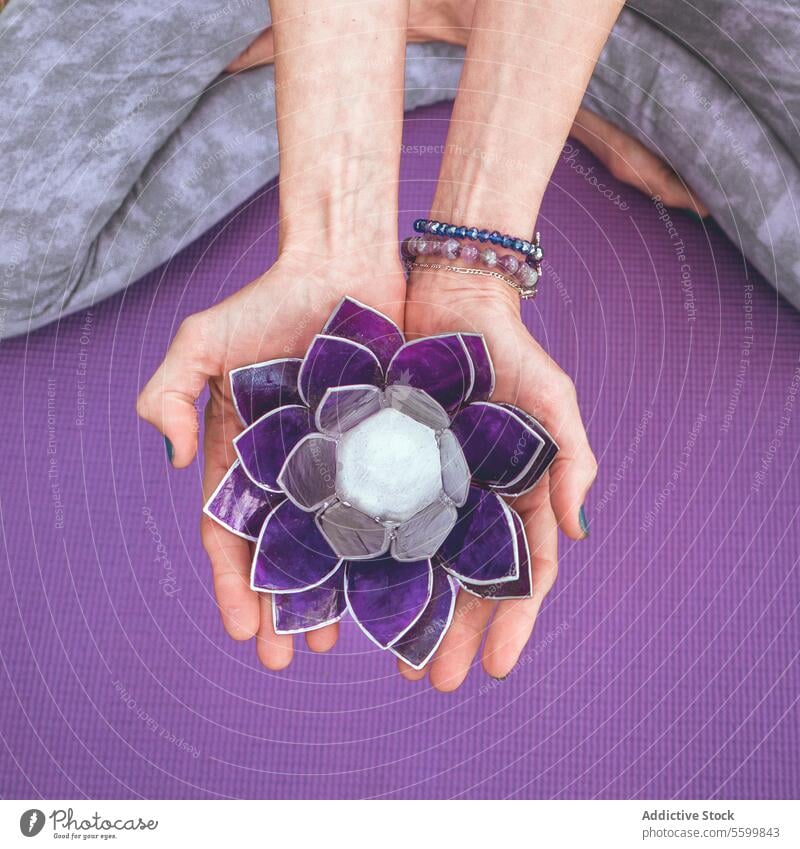 Top angle view of hands holding a purple glass lotus.  Yoga and meditation concept. Close-up aesthetic aquatic balance beautiful beauty calm calmness close up