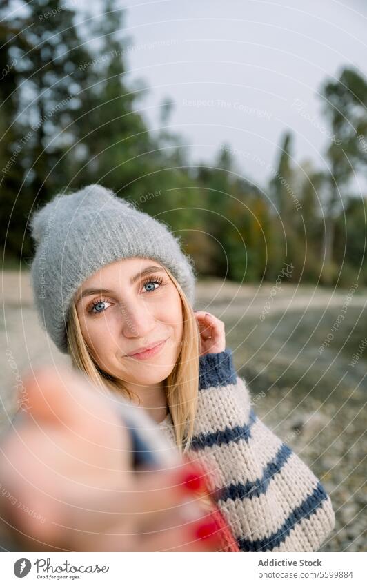 Smiling woman taking selfie female knitted countryside style sweater trendy hat warm smile nature young lady happy cheerful appearance joy casual modern