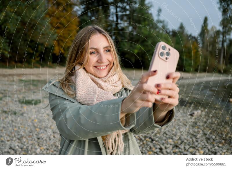 portrait of young woman taking selfie at lake person alone female phone vacation girl nature happy lifestyle water freedom caucasian mobile leisure holiday