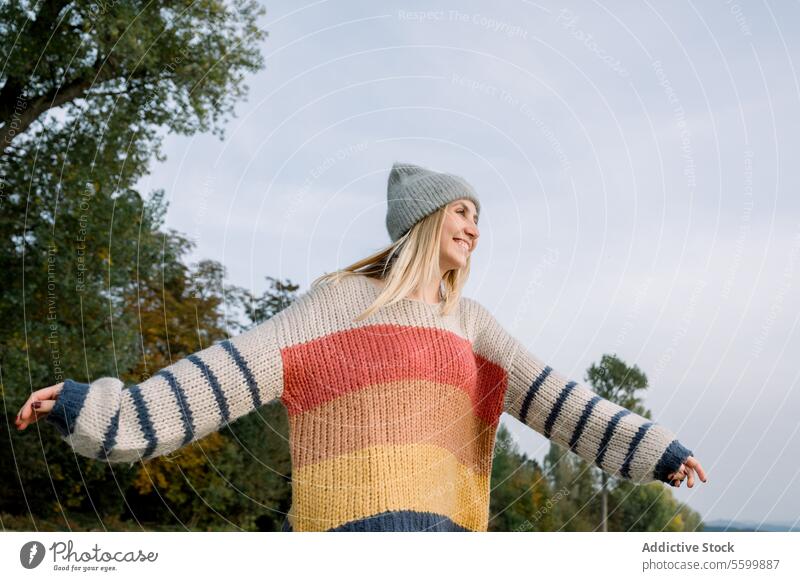 Happy woman with arms outstretched wearing knitwear and hat enjoyment horizontal relaxation carefree one person smile warm canada vitality walk freedom weather