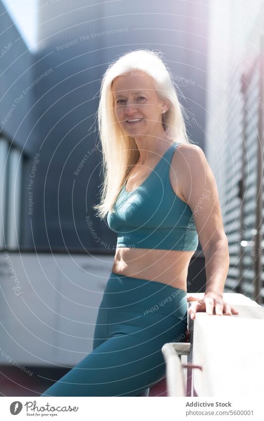 Happy senior woman in activewear enjoying urban lifestyle mature fitness health city workout confident posing exercise fashion stylish wellbeing outdoors