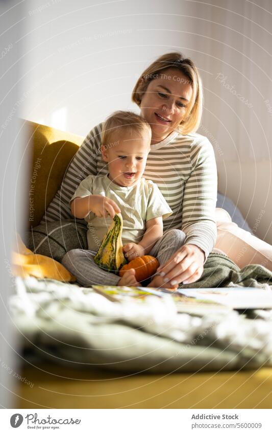 Mother and child sharing a moment with a book mother toddler reading picture book bonding pumpkin childhood learning education family quality time togetherness