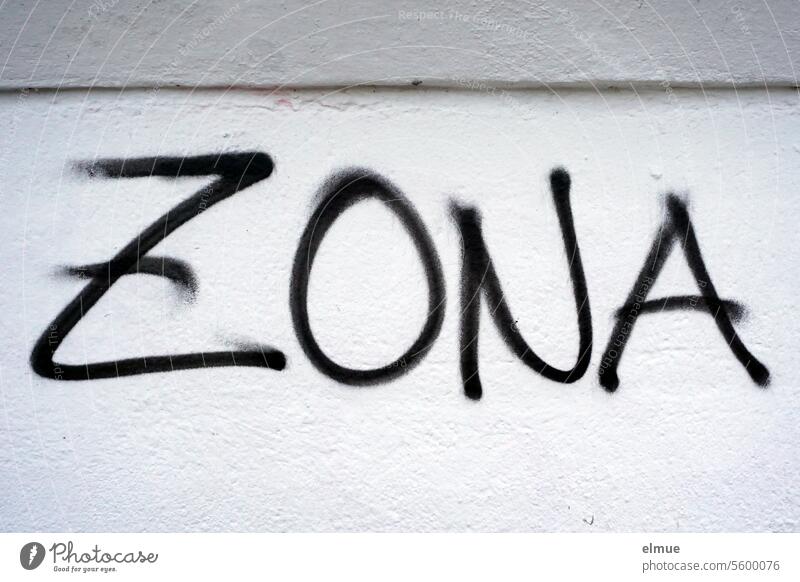 ZONA stands in black on a gray wall Zona Graffiti Zone demarcation areal Daub Mural painting spray Youth culture Lifestyle Shingles Wall (building) Blog