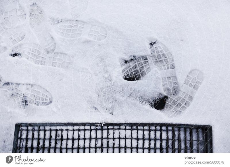 Shoe prints from work shoes in the snow in front of a grating shoe print Scraper grate Metal grid Winter Snow Snow layer everyday working life footprints