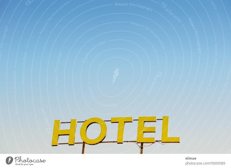 yellow HOTEL lettering against a light blue sky Hotel Accommodation overnight Signs and labeling Vacation & Travel Advertising Neon sign Blog Tourism Hostel