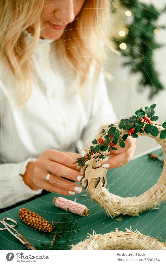 A woman is crafting a wreath for Christmas. Natural natural decoration, DIY, traditional Christmas celebration. occasion present from above event celebrate