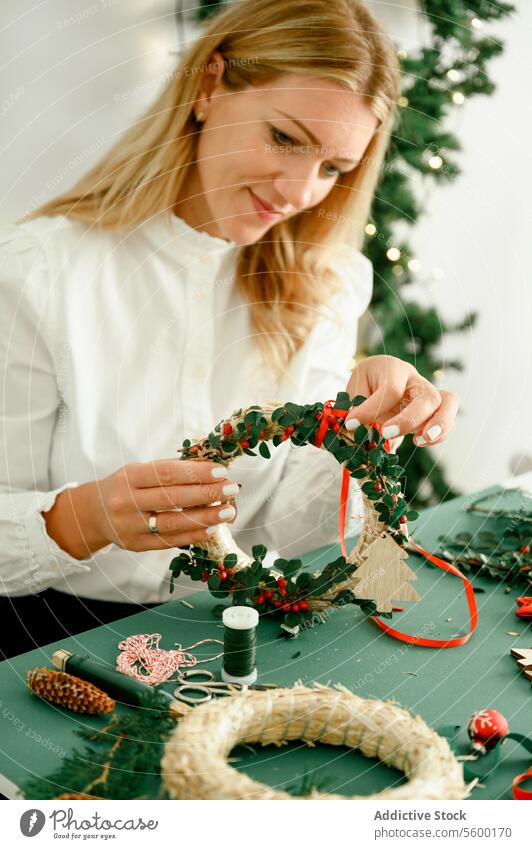 Woman making christmas wreath background lights festive hobby tradition workshop creativity tool ornate small business hip horizontal ring greeting ribbon