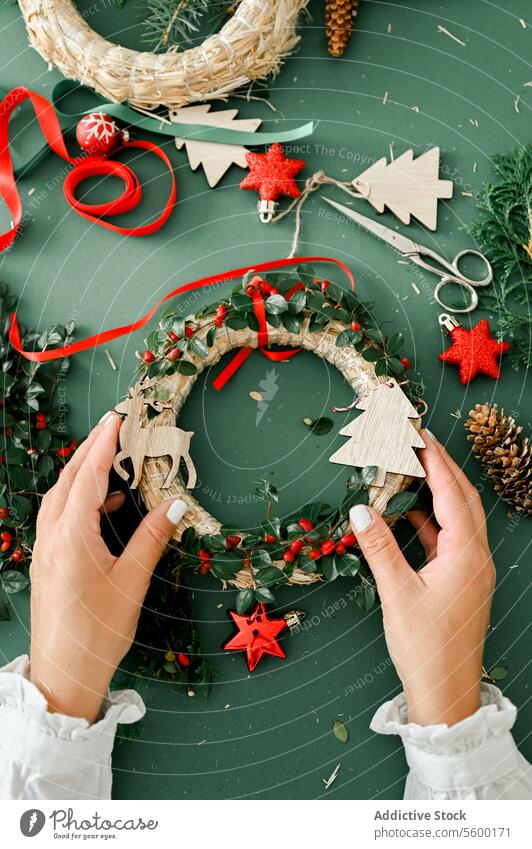 Woman holding Christmas wreath in hands person craft tradition diy female decorating creativity advent gift festive photography color image horizontal xmas