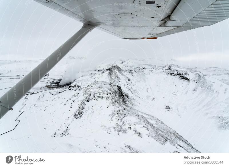 Aerial View of Snow-Covered Mountains from Plane aerial view snow-covered mountains plane aircraft rugged horizon expansive nature altitude winter landscape