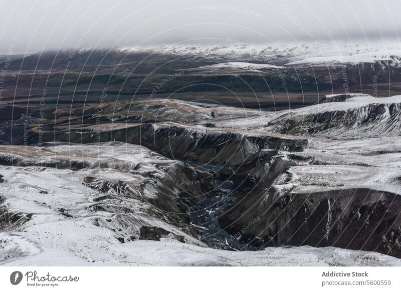 Aerial view of river and Snowy Canyon snowy canyon vista imposing snow-draped rugged landscape mountain ridges gloomy sky nature winter cold outdoor wilderness