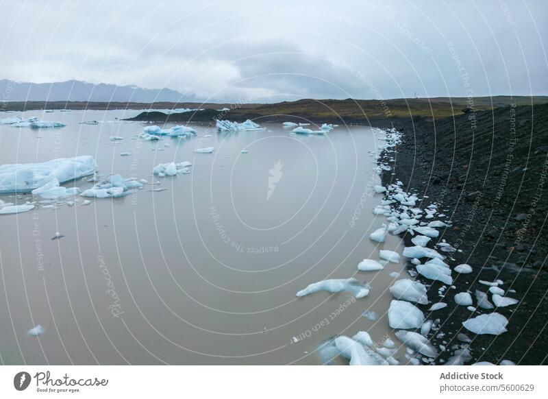 Glacial Waters and Volcanic Shore wide angle view iceberg water tranquil volcanic ash shore glacial landscape Vatnajökull National Park Iceland calm cold arctic