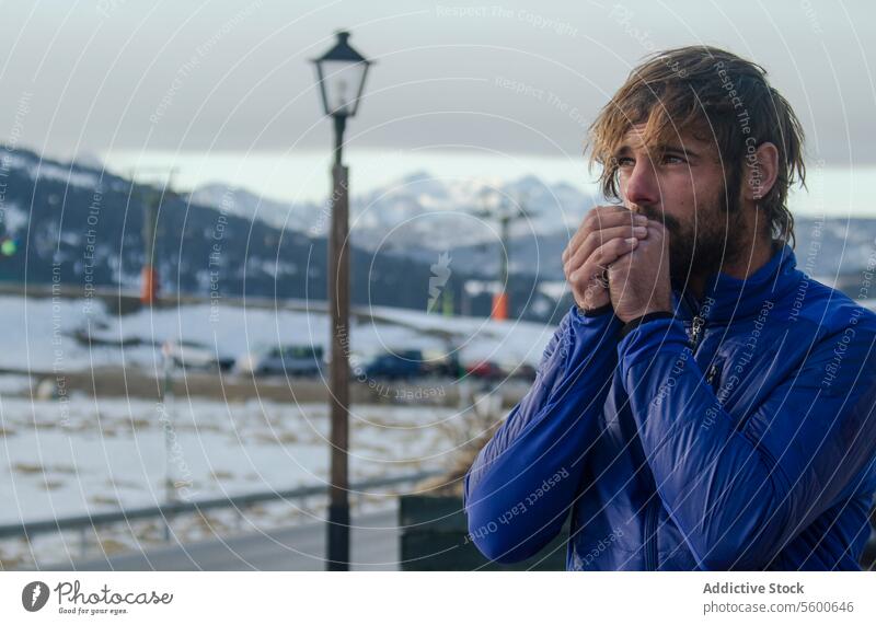 Warming Up in the Chilly Swiss Alpine Air man cold breath swiss alps mountain snow winter outdoors warming landscape nature jacket hiker travel frosty hand