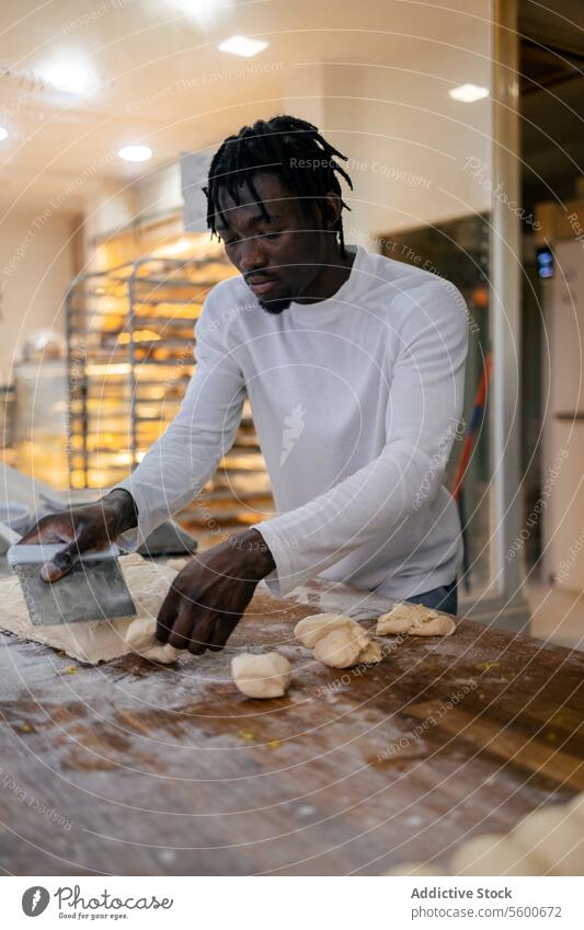 Black baker cutting dough with scapula black afro bread preparation bakery making flour raw table fresh cutter utensil pastry working kneading handmade