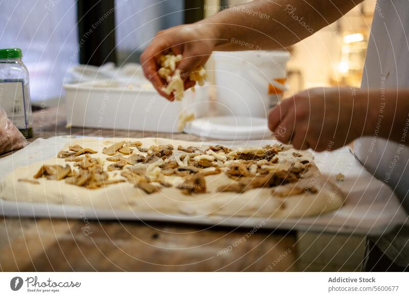 Hands adding ingredients to pizza close-up hands baker kitchen food dough mushroom cheese focaccia cooking young flour cuisine person recipe table prepare