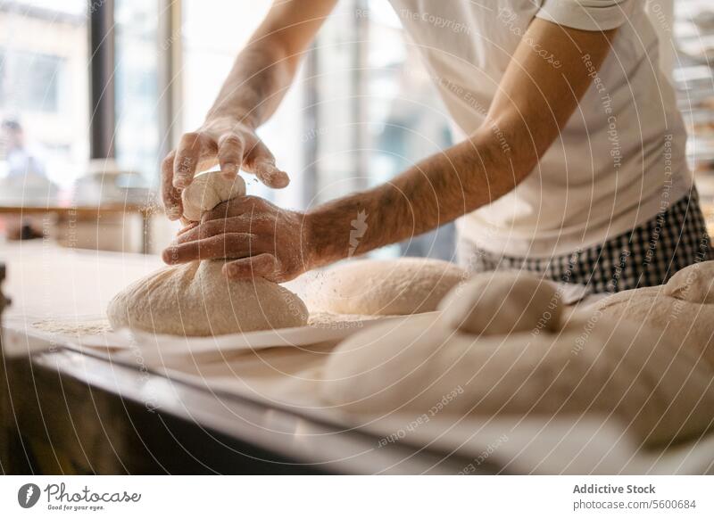 Unrecognizable baker making shape in bread dough portrait close-up bakery flour fresh unrecognizable hands food raw oven wheat kitchen yeast occupation