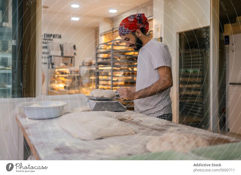 Arabic baker weighting dough with scale arabic scapula bread preparation bakery making happy smile flour raw table fresh cutter utensil pastry working kneading