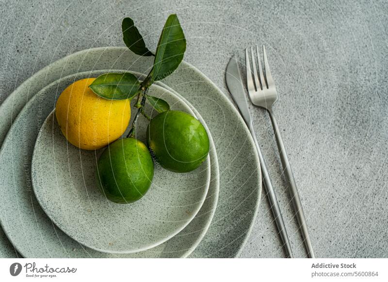 Citrus Fruits on Stacked Ceramic Plates citrus fruits ceramic plates stacked modern kitchen aesthetics natural elements overhead lemon lime green yellow