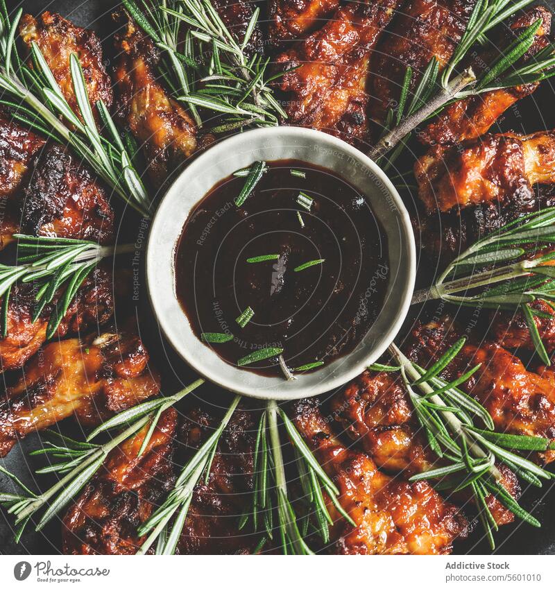 Close up of BBQ chicken wings with rosemary and homemade sauce. Cooking at home with marinated meat. Delicious finger food. Top view. close up bbq cooking