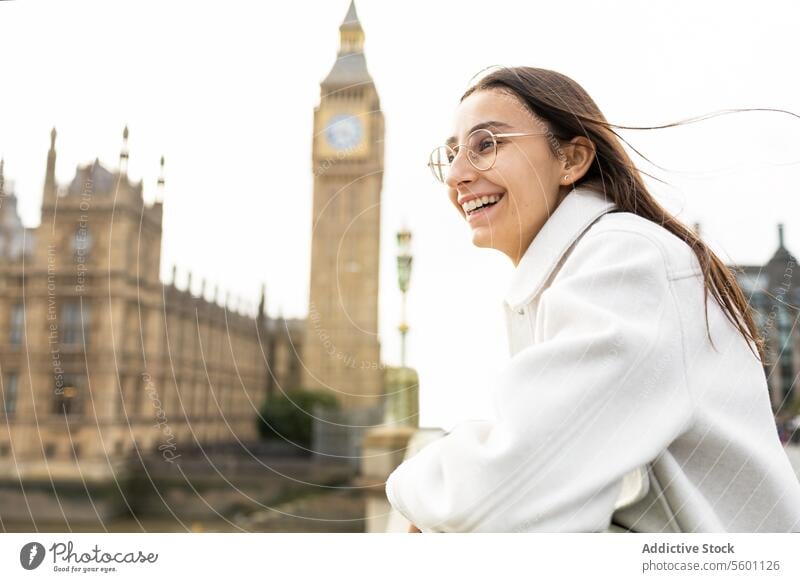 Cheerful woman enjoying sightseeing near Big Ben in London london big ben smile tourist happy sunglasses stylish travel landmark tourism iconic city urban