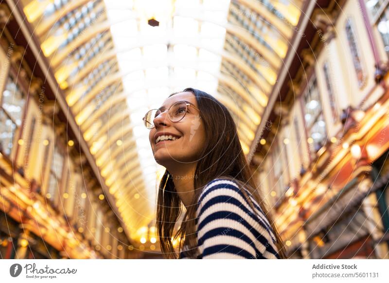 Smiling Young Woman Exploring Indoor London Market woman smiling london market indoor exploration architecture travel tourist young cheerful admiration iconic