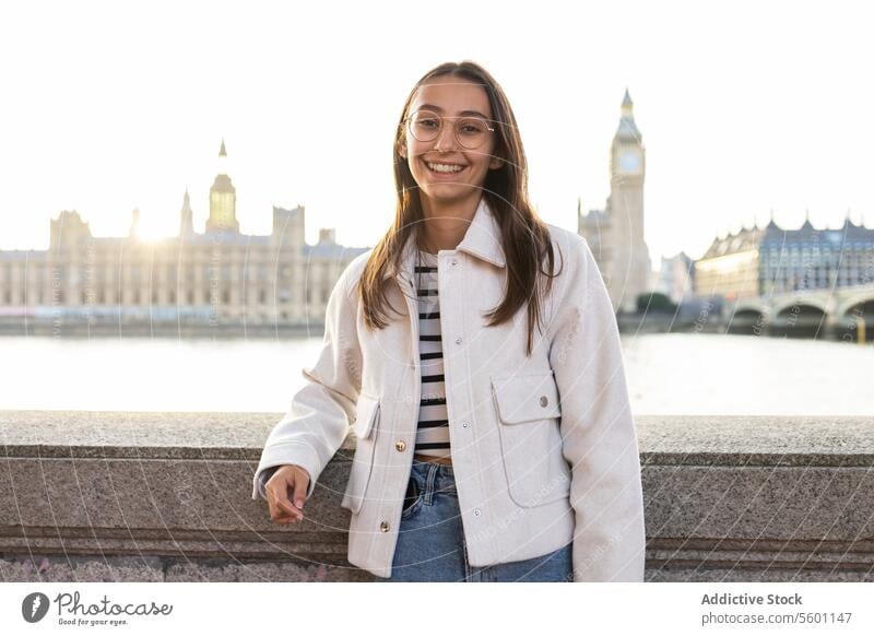 Smiling young woman enjoying in London with Big Ben at the background smiling london big ben parliament sunny day thames fashion coat happy travel tourism