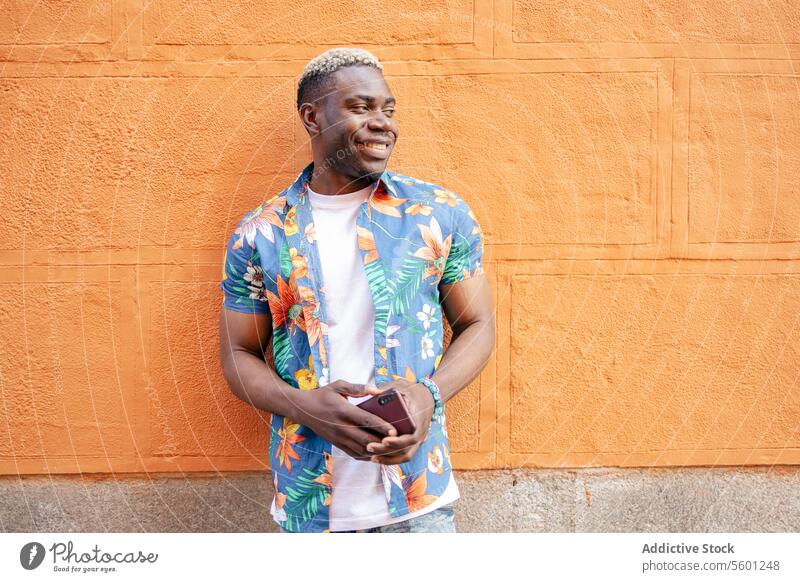 Portrait of a young black man in the street portrait smile smiling happiness urban african city lifestyle male person adult guy smartphone technology handsome