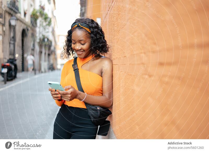 Portrait of a young black woman using smartphone in the street lifestyle happy technology texting smiling mobile person portrait beautiful girl adult