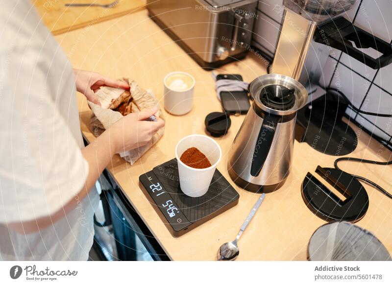 Young barista weighing coffee unrecognizable cafe espresso cafeteria close-up latte drink weighting scale cappuccino caffeine business worker job service