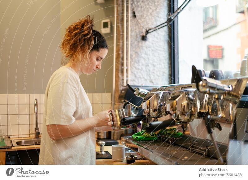 Young barista steaming milk coffee cafe espresso cafeteria latte drink cappuccino caffeine business worker job service occupation machine staff young person