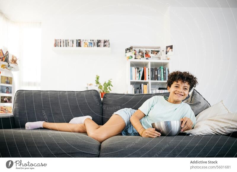 Girl watching tv in living room Family Preteen daughter Tv adorable cheerful child childhood children couch cute female fun girl happiness happy home indoors