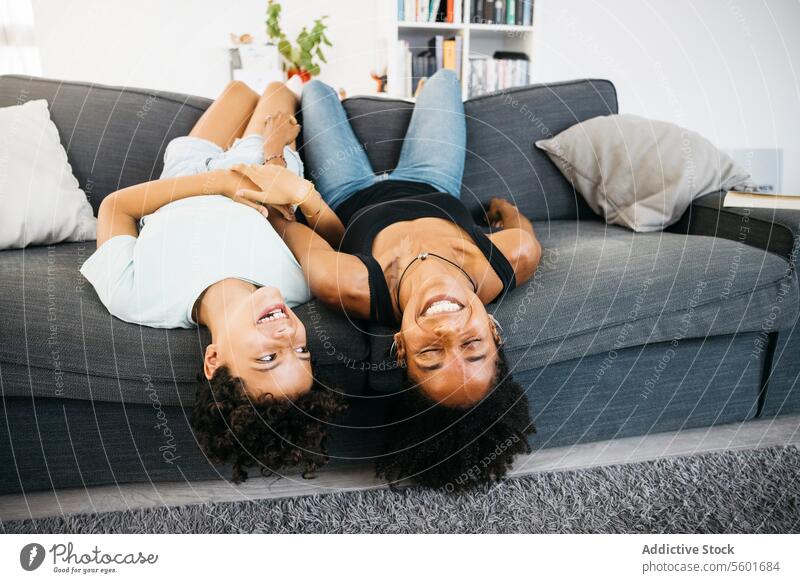 Mother and daughter playing together Family Preteen daughter Tv adorable affectionate bonding cheerful child childhood children couch cute enjoyment family life
