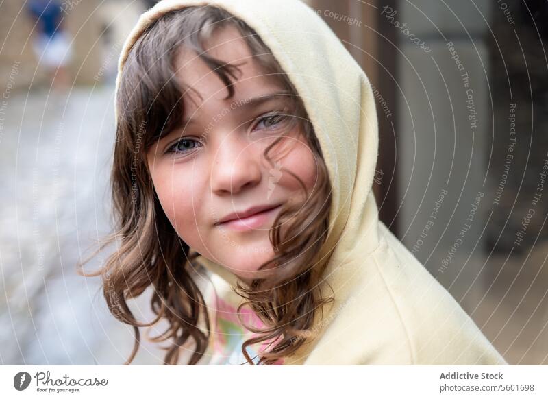 Smiling child girl with hood looking at camera Child smile portrait outdoor rain happy youth kid cheerful innocence joy face casual clothing cute childhood