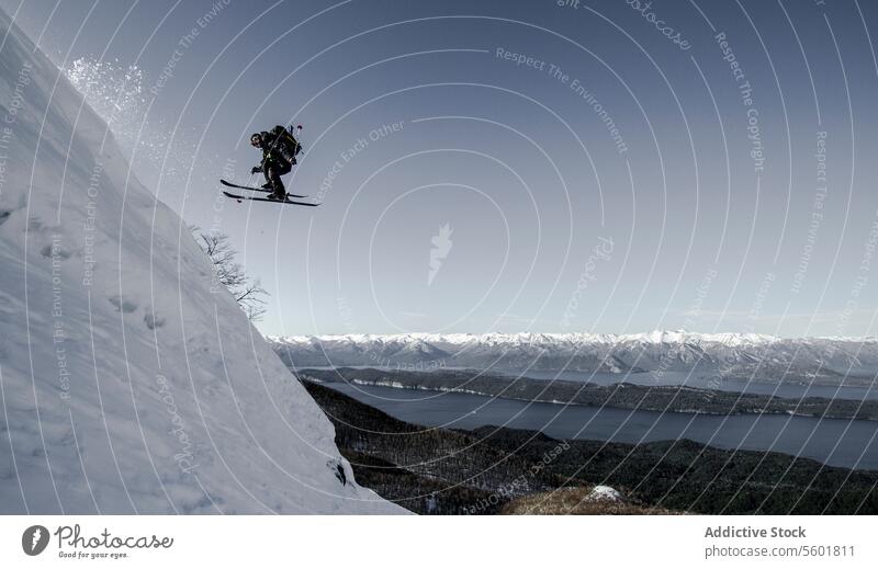 Person skiing on snowy mountain in winter person jump slope snowcapped clear sky vacation speed powder active unrecognizable skier covering highland motion