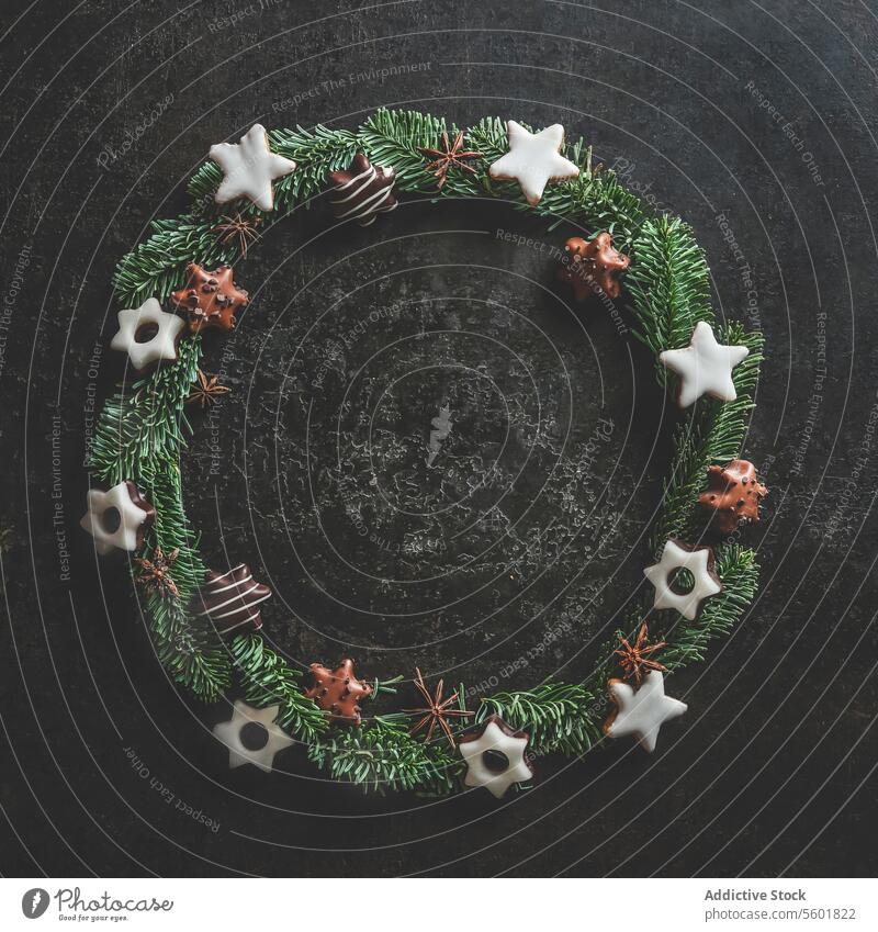 Christmas circle frame made with fir wreath and cookies on dark concrete kitchen table. Christmas background with copy space. Top view. christmas background