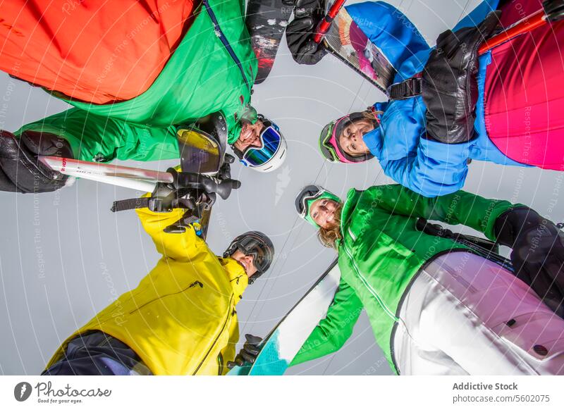 Circle of skiers ready for descent in colorful gear circle snow landscape vibrant apparel low-angle group winter sport outdoor activity friendship team together