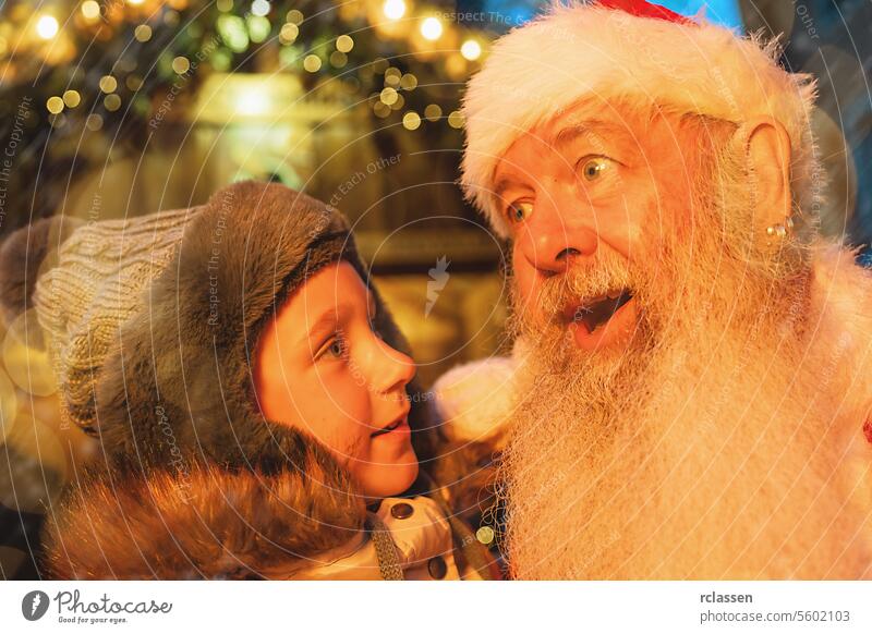 Child in awe with Santa Claus at a Christmas market, surrounded by festive lights joy joyful merry christmas gloves traditional mulled wine christmas market