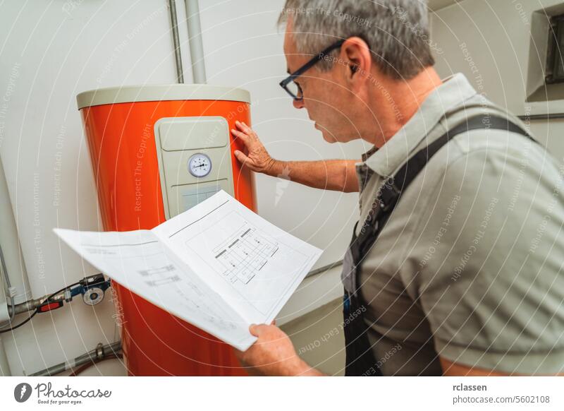 Heating engineers checks a old gas heating system with a paper instruction at a boiler room in a house. Gas heater replacement obligation concept image