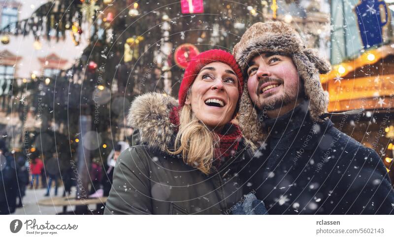 Woman and man on Christmas Market in front of tree friends mulled wine boyfriend beard tourism dating fair travel happy couple love new year christmas market