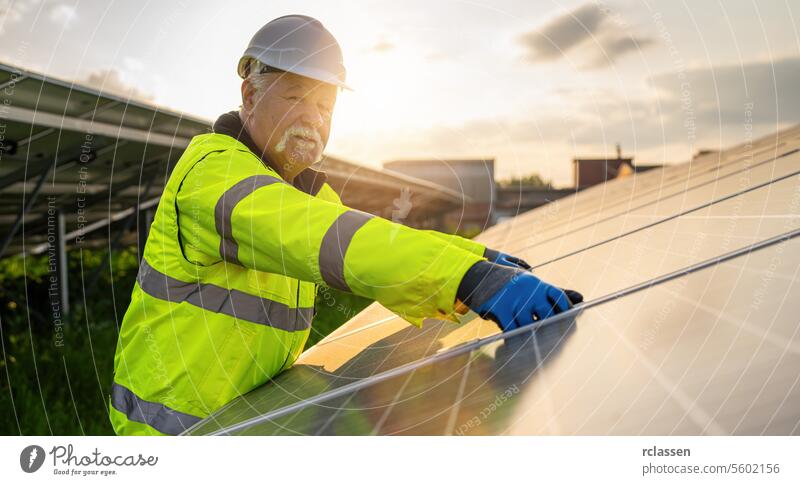 Senior engineer assembling solar panels at an energy farm during sunset. Alternative energy ecological concept image. technology plant industry electricity