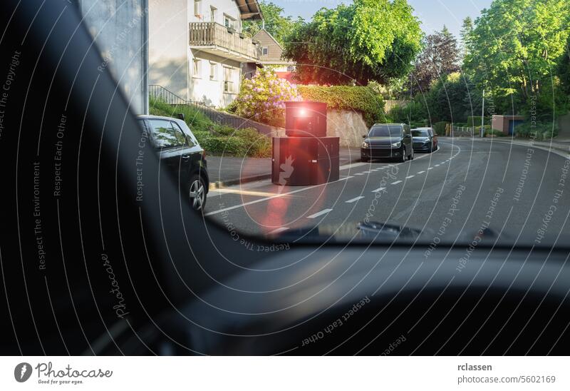 View from car of speed camera on street, another car approaching, residential neighborhood road safety residential street approaching car driving perspective